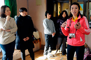 見学中の父兄に子どもたちが実践している運動の目的を説明する佳苗さん(右)